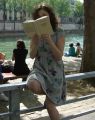 An unknown girl reads Gabriel Matzneff on the banks of the Seine